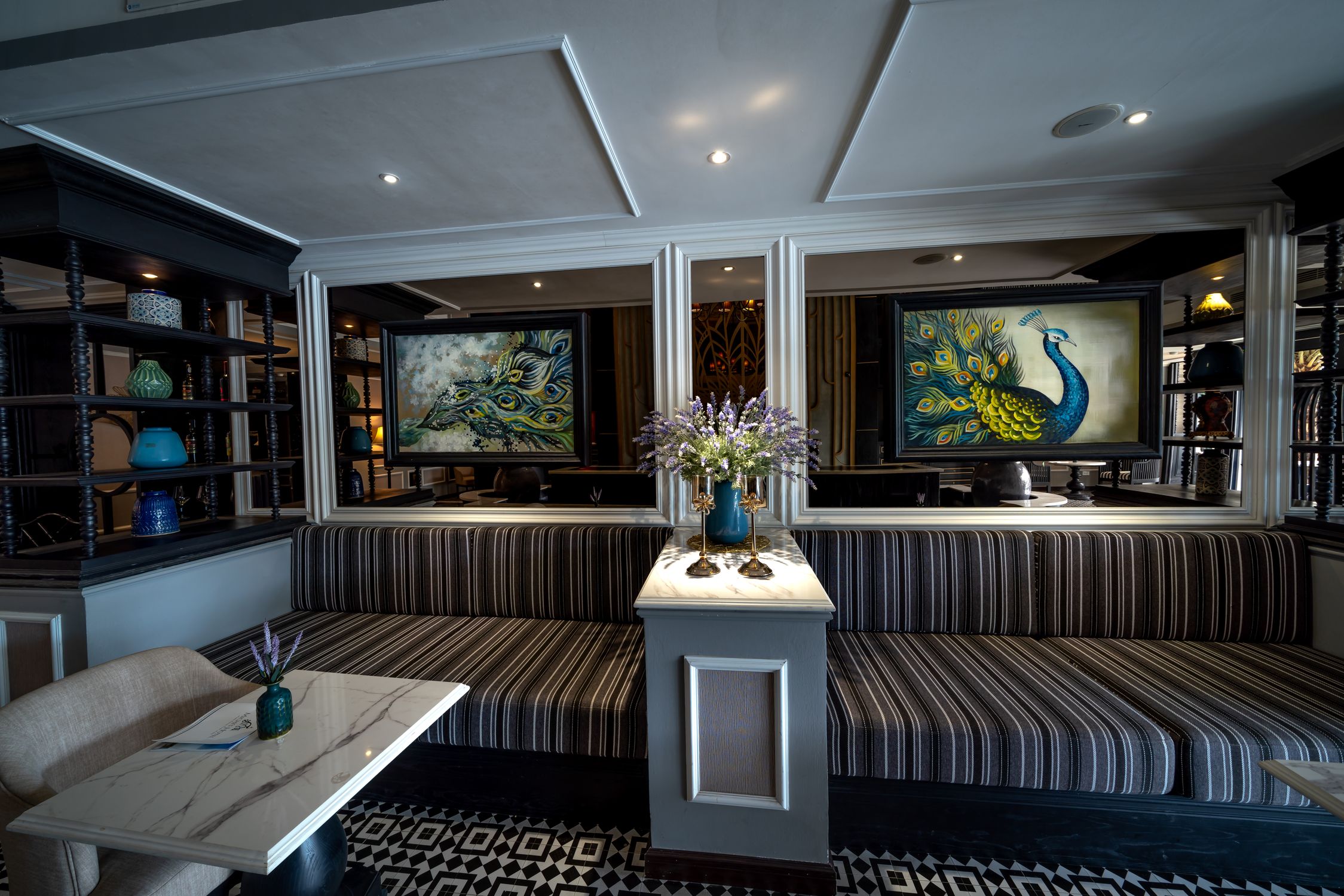 Luxurious hotel foyer adorned with peacock paintings and elegant seating. Perfect for relaxation.