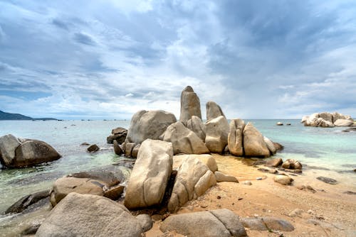 Free Gray Rock Formation on Sea Under Blue Sky Stock Photo