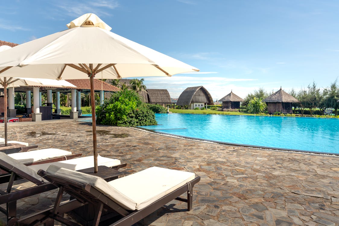 Sun Loungers and Sun Umbrellas by the Pool in a Tropical Resort 