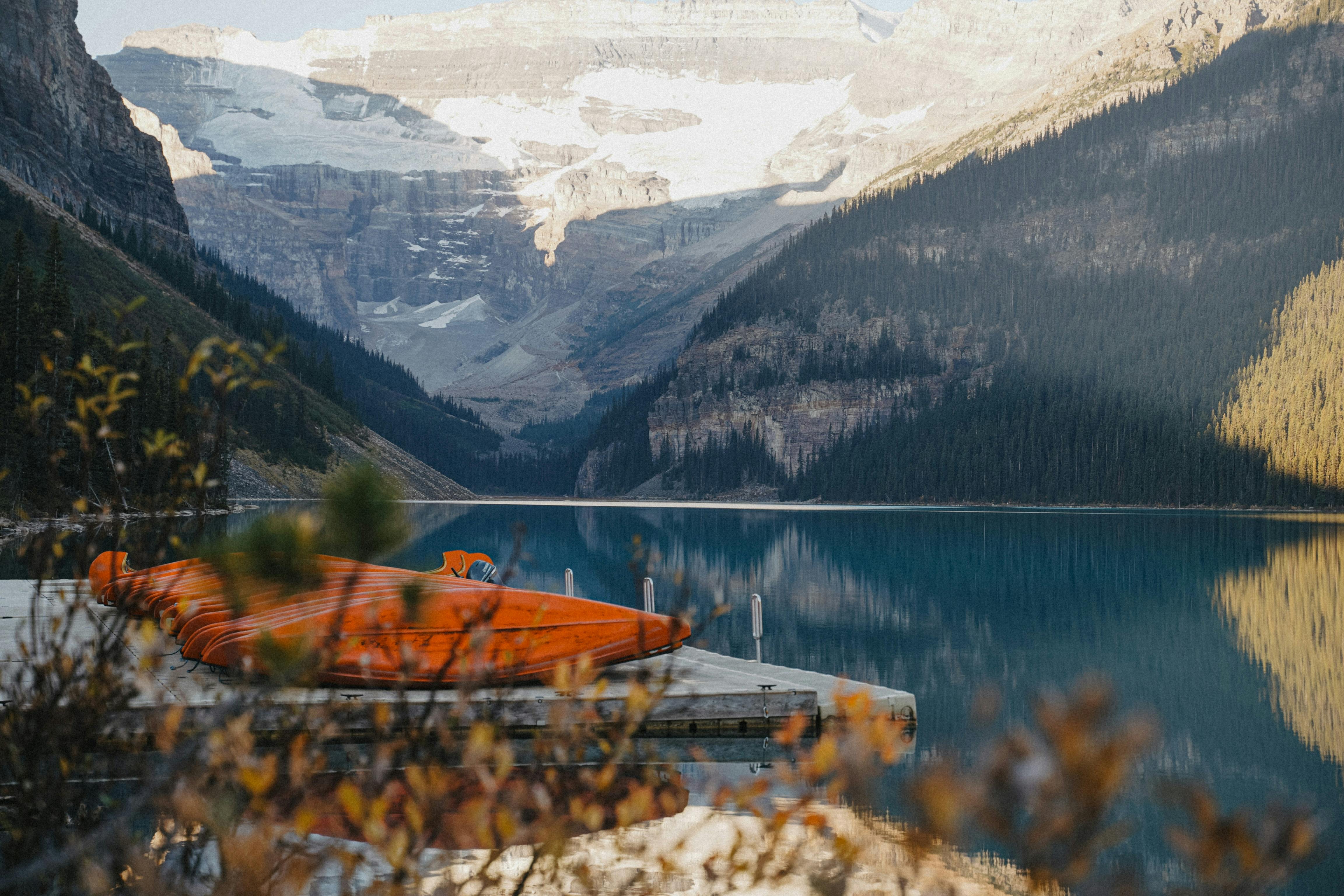 Majestic scene of kayaks at Lake Louise with snow-capped mountains in beautiful Banff National Park.