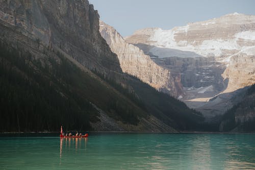 People Kayaking Across a Scenic Alpine Lake