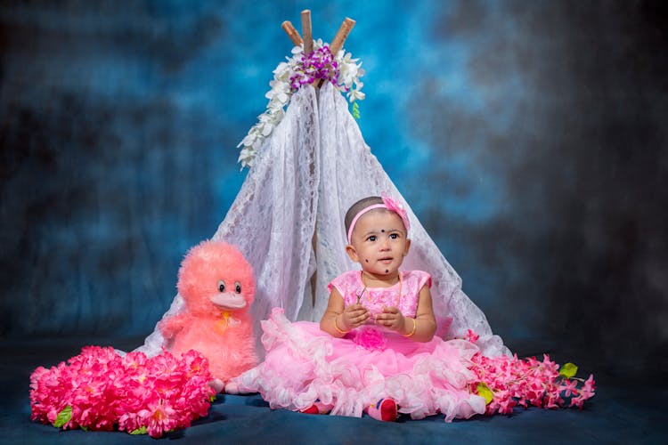 Child Girl Sitting With A Plush Duck Toy