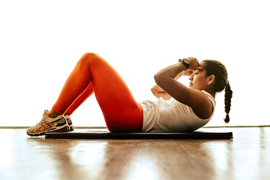 Side view of a young woman doing sit-ups on a mat, focusing on fitness and strength.