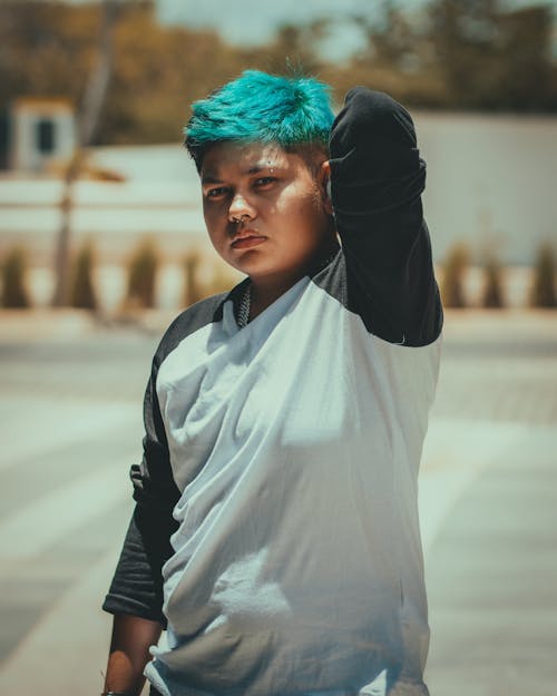 Woman in White and Black Long Sleeve Shirt With Blue Green Hair