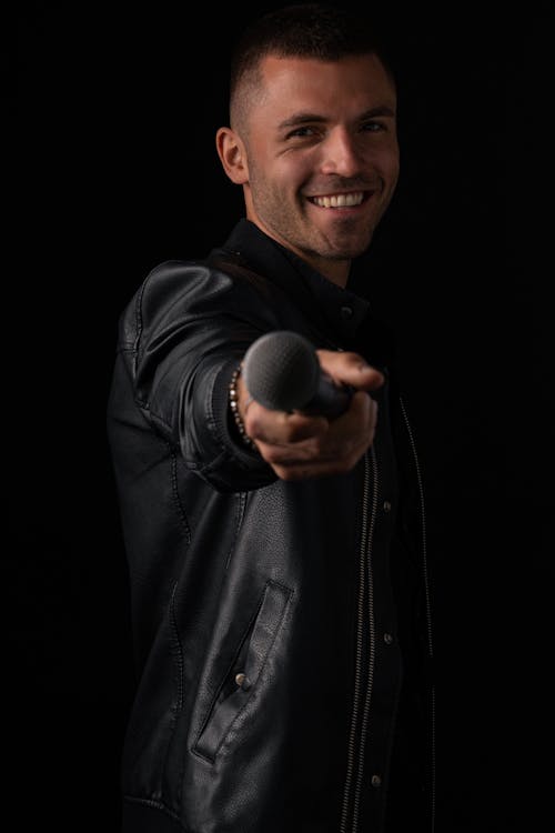 A Man in Black Leather Jacket Holding a Microphone