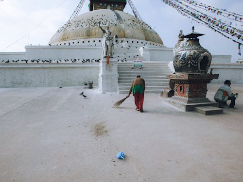 A Person Cleaning the Boudhanath Stupa Buddhist Temple in Kathmandu Nepal