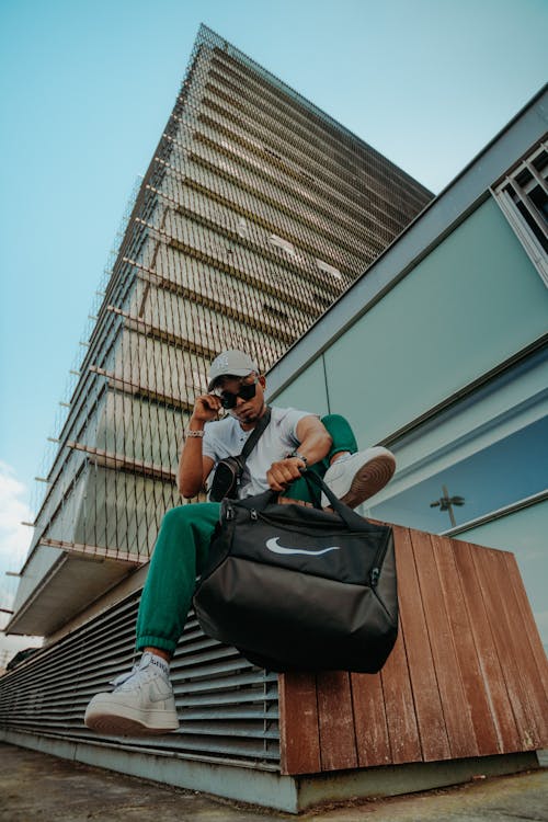 Fotos de stock gratuitas de bolso negro, foto de ángulo bajo, hombre