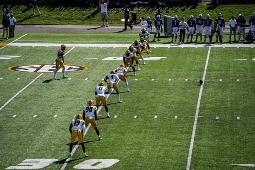 Aerial shot of an American football game kickoff with players in action.