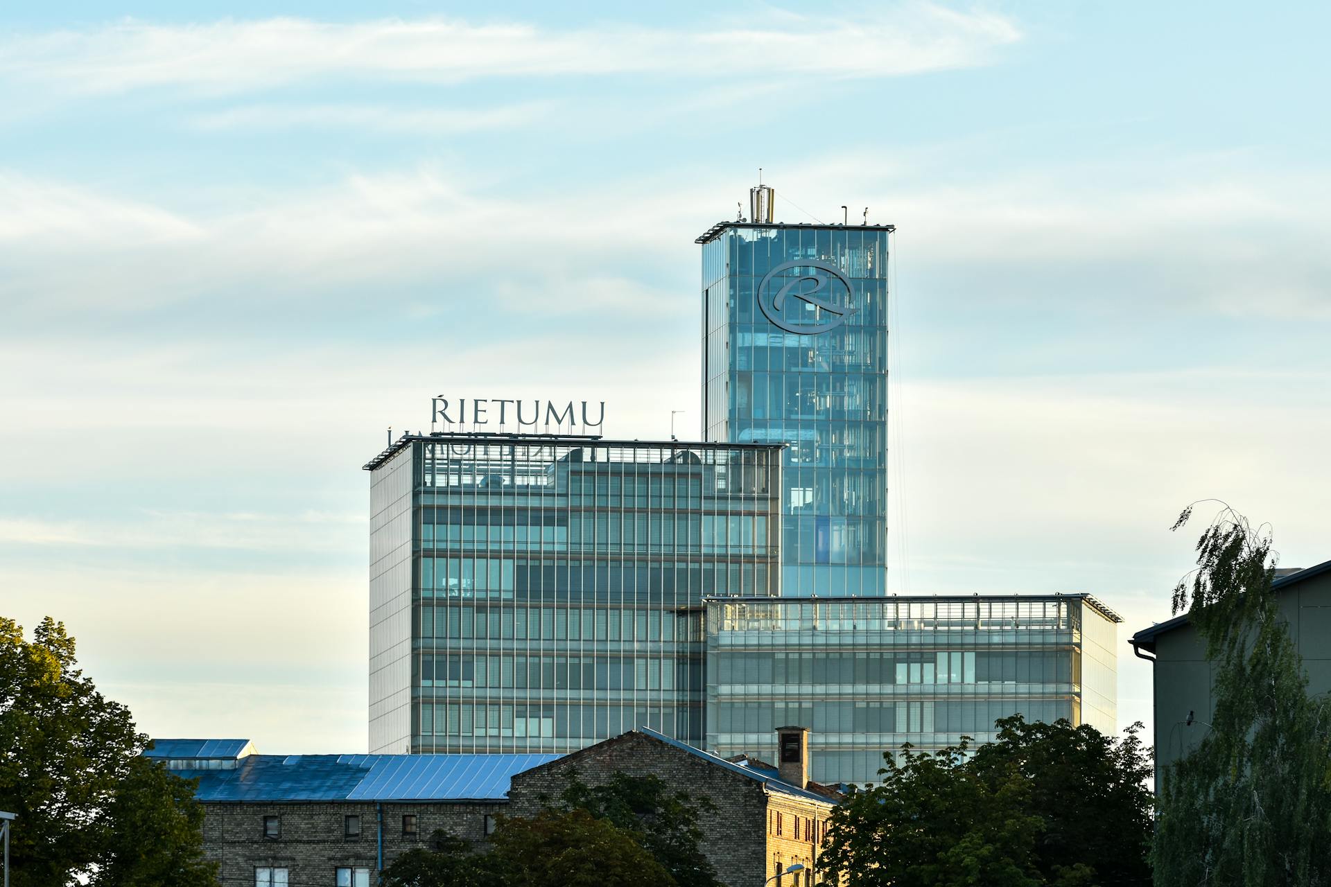 The sleek architecture of the Rietumu Bank building against a summer sky in Riga, Latvia.