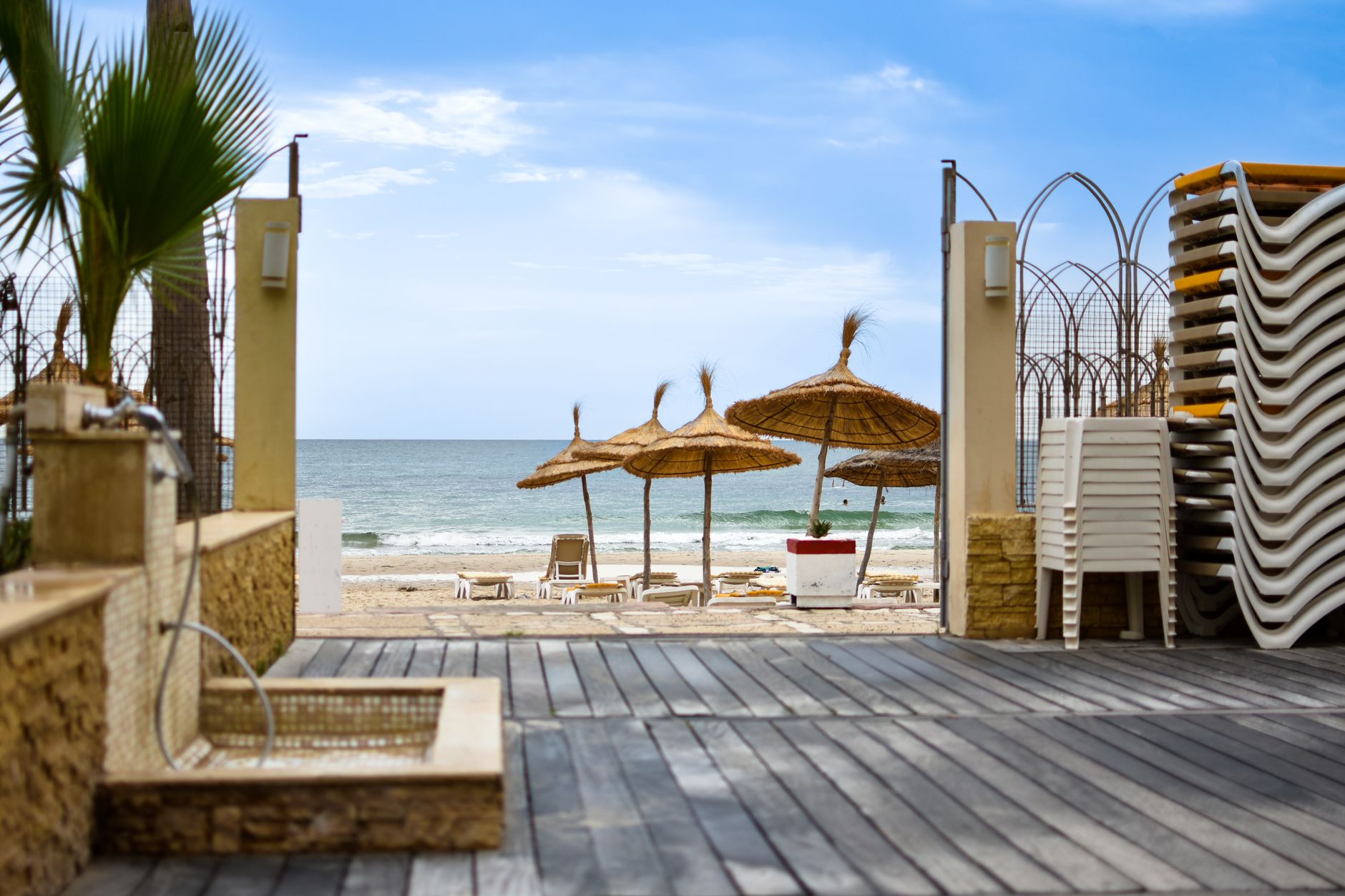 Tranquil beach scene with straw umbrellas and lounge chairs in Tunis, Tunisia.
