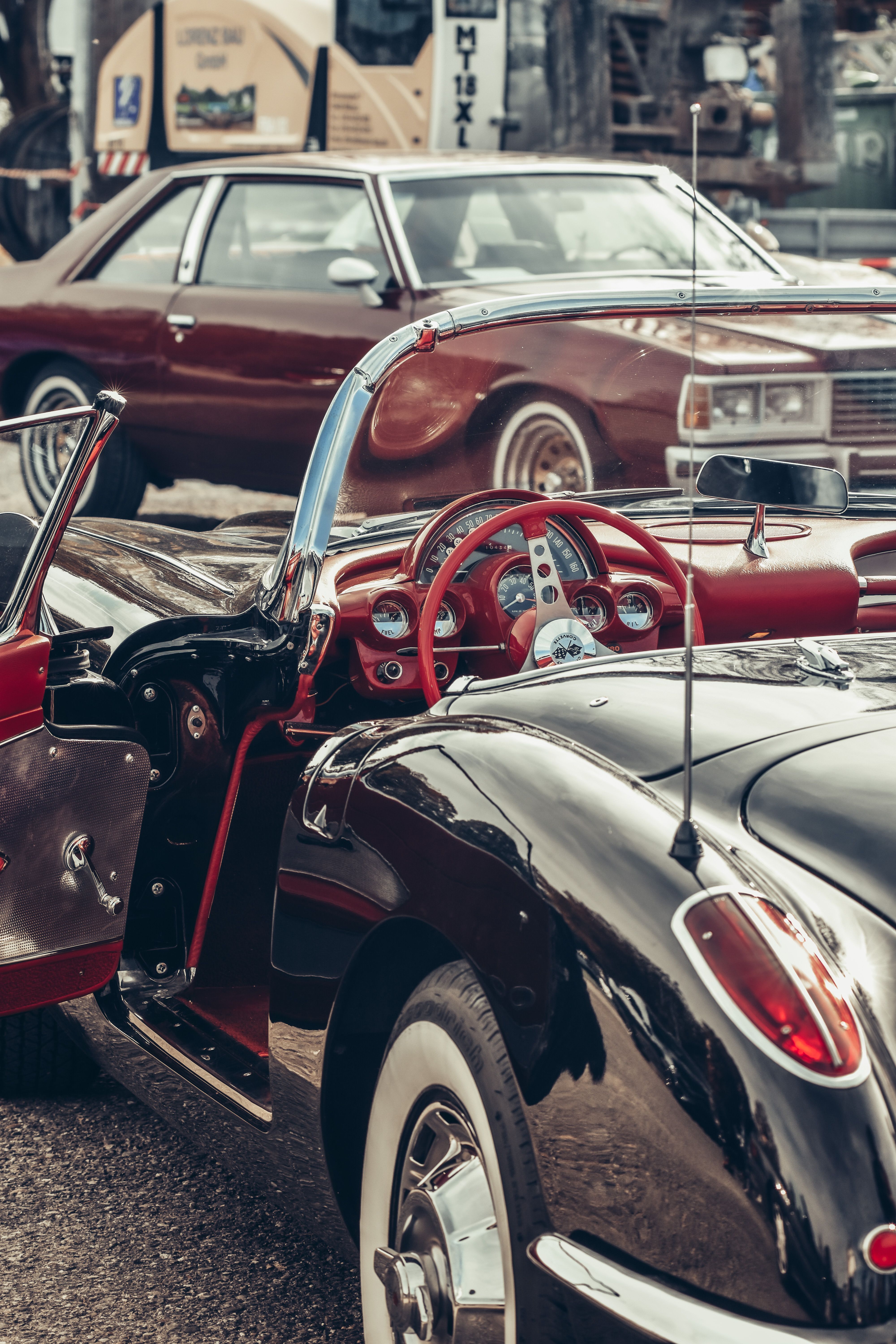 Vintage convertible car with open door at an outdoor car exhibition.