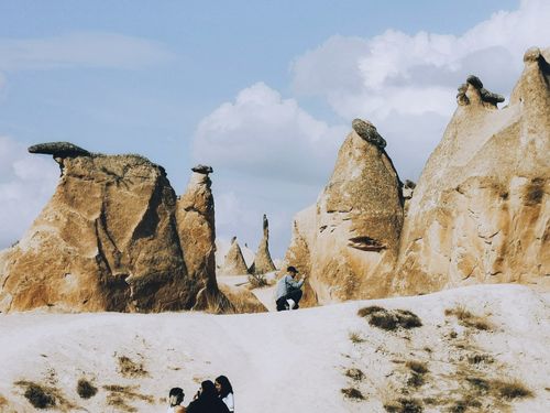 Free Tourists capture stunning rock formations in Cappadocia, a unique landscape feature. Stock Photo