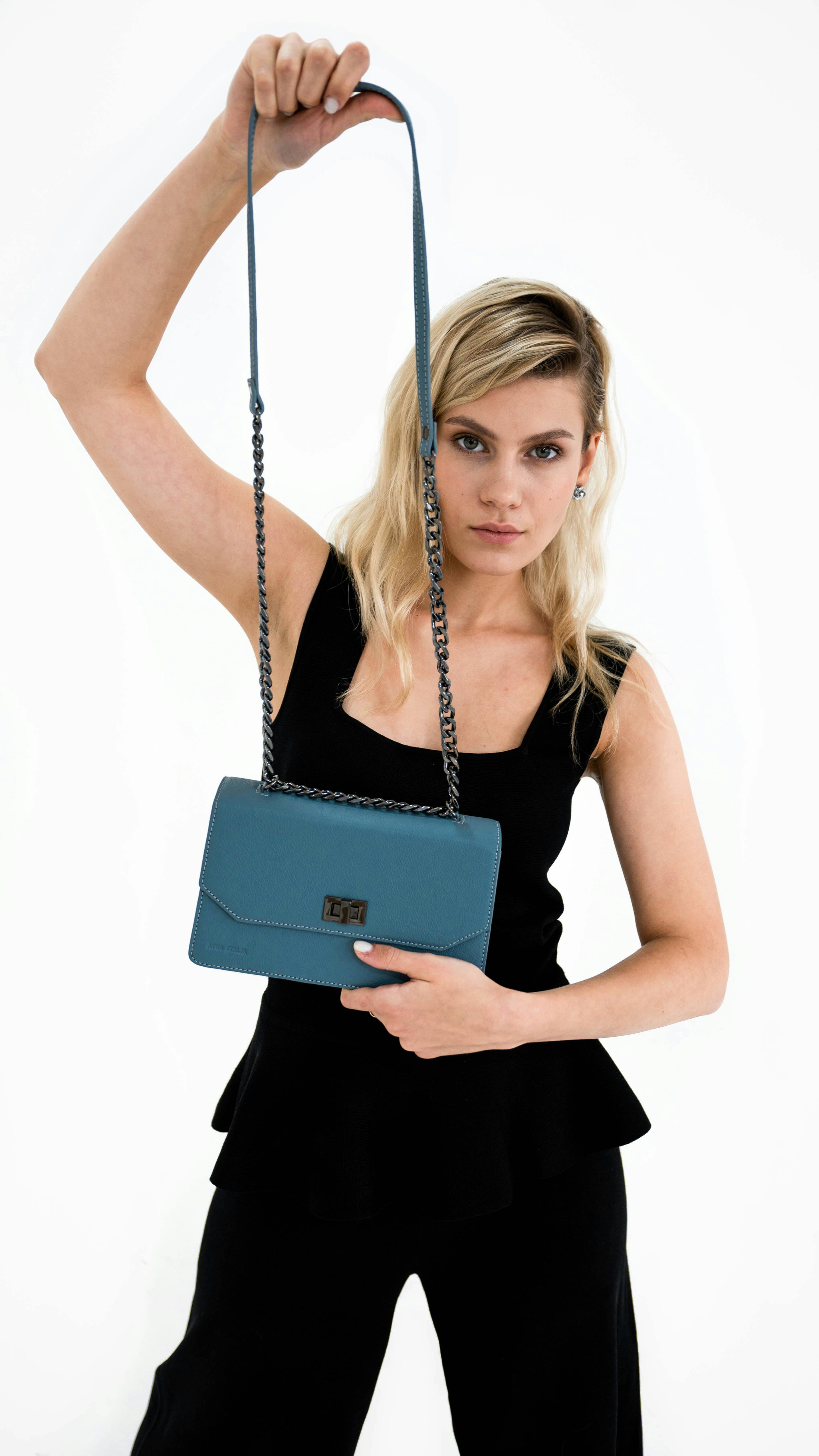 A Woman in Black Dress Holding a Shoulder Bag · Free Stock Photo