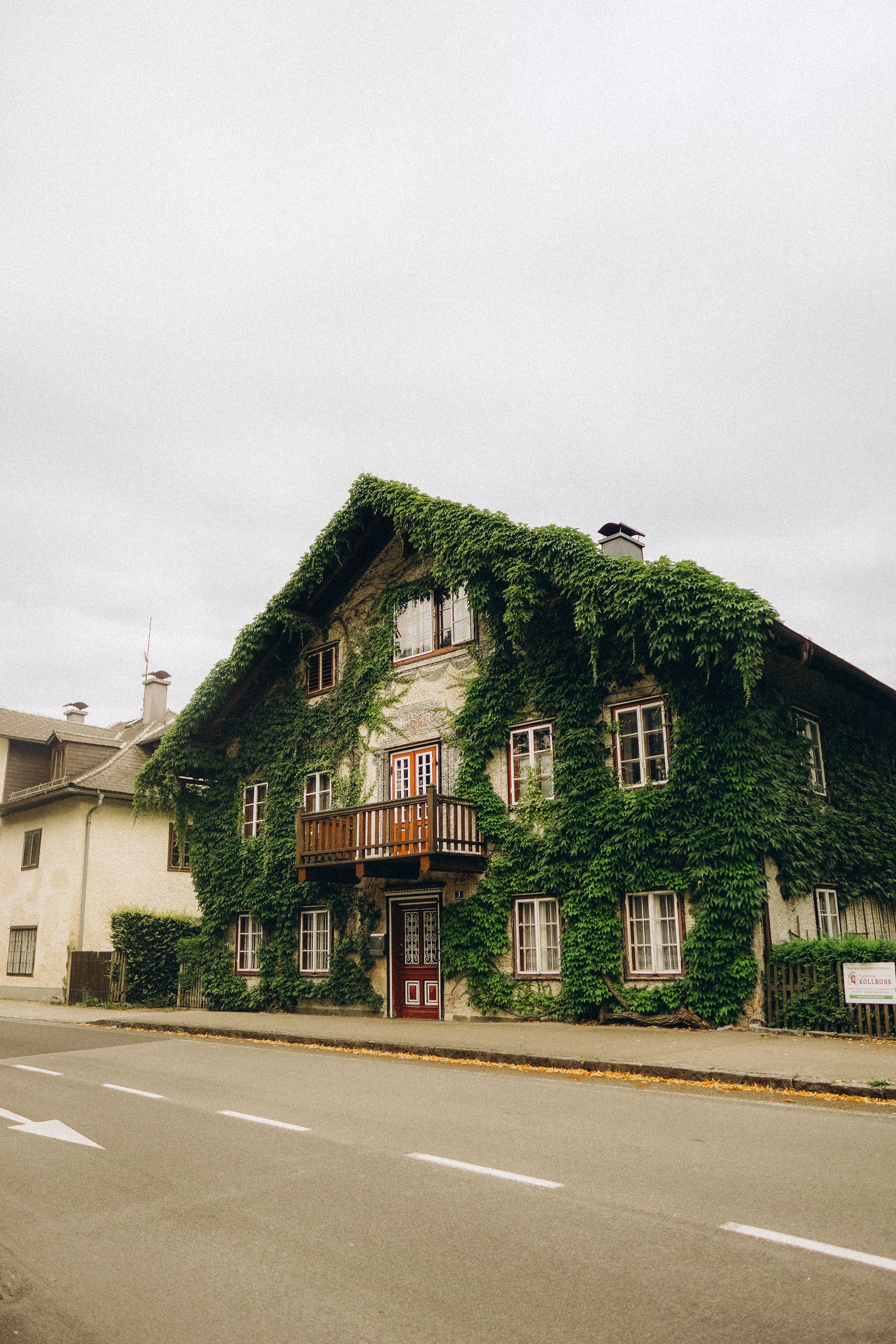 A beautiful ivy-clad house with vintage charm and rustic architecture stands on a quiet street.