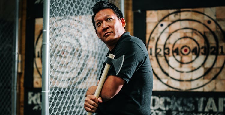 Man Holding An Axe In An Axe Throwing Facility 