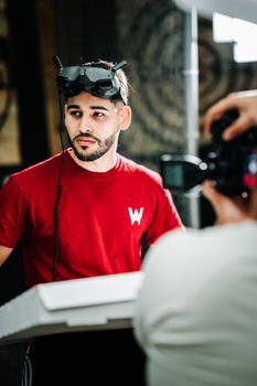 A male photographer wearing a VR headset in a studio environment, captured during a photoshoot.