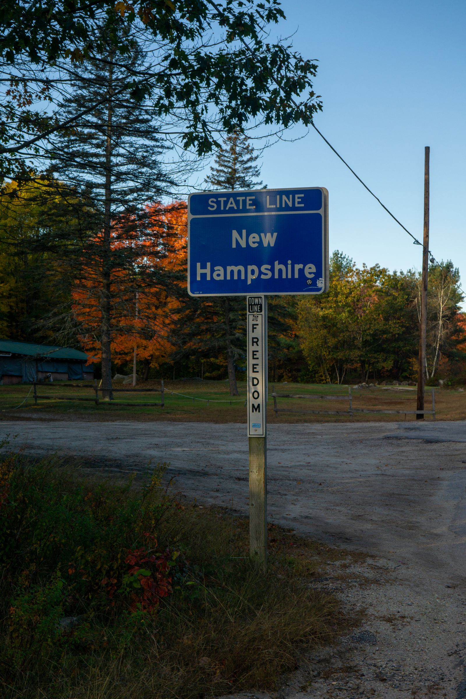 Welcome to New Hampshire state line sign with autumn foliage