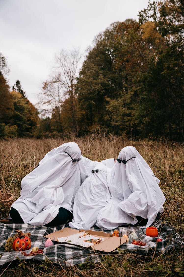 People In Ghost Costumes Having Picnic In Park