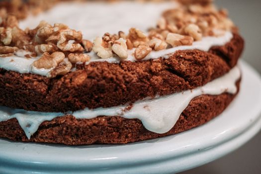 Close-up of a freshly baked walnut dessert with creamy frosting.
