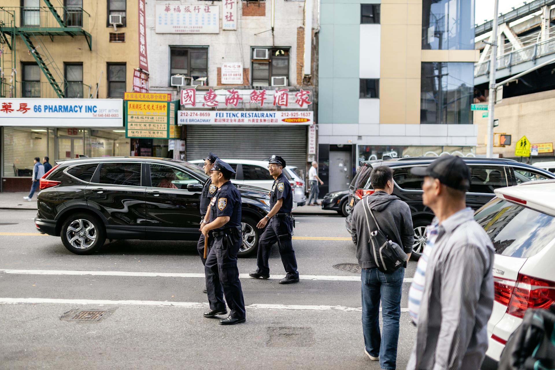 Policemen Walking on a Street Near Vehicles