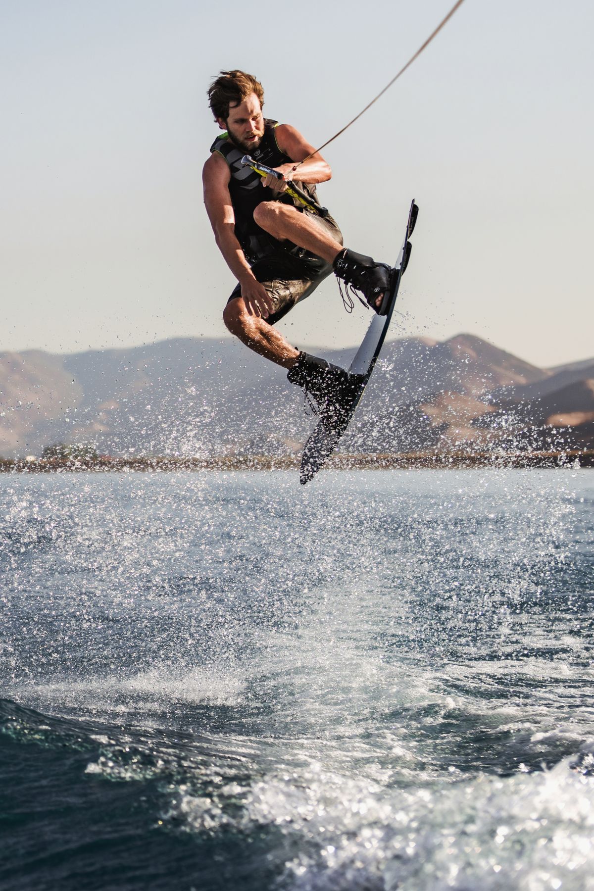 Wakeboarder launching off the wake with a big spray