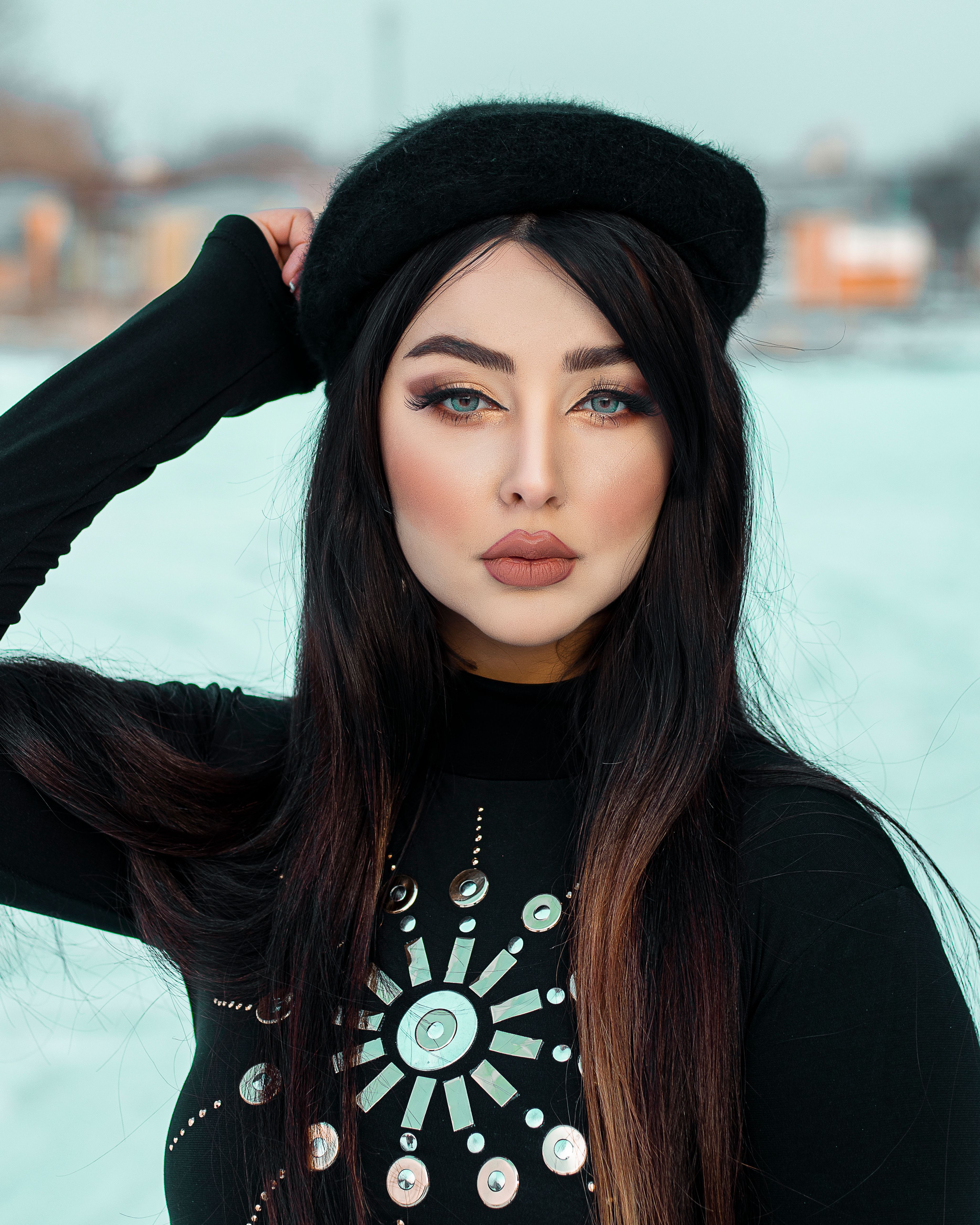 Portrait of a fashionable woman wearing a knit cap, posing outdoors in winter.