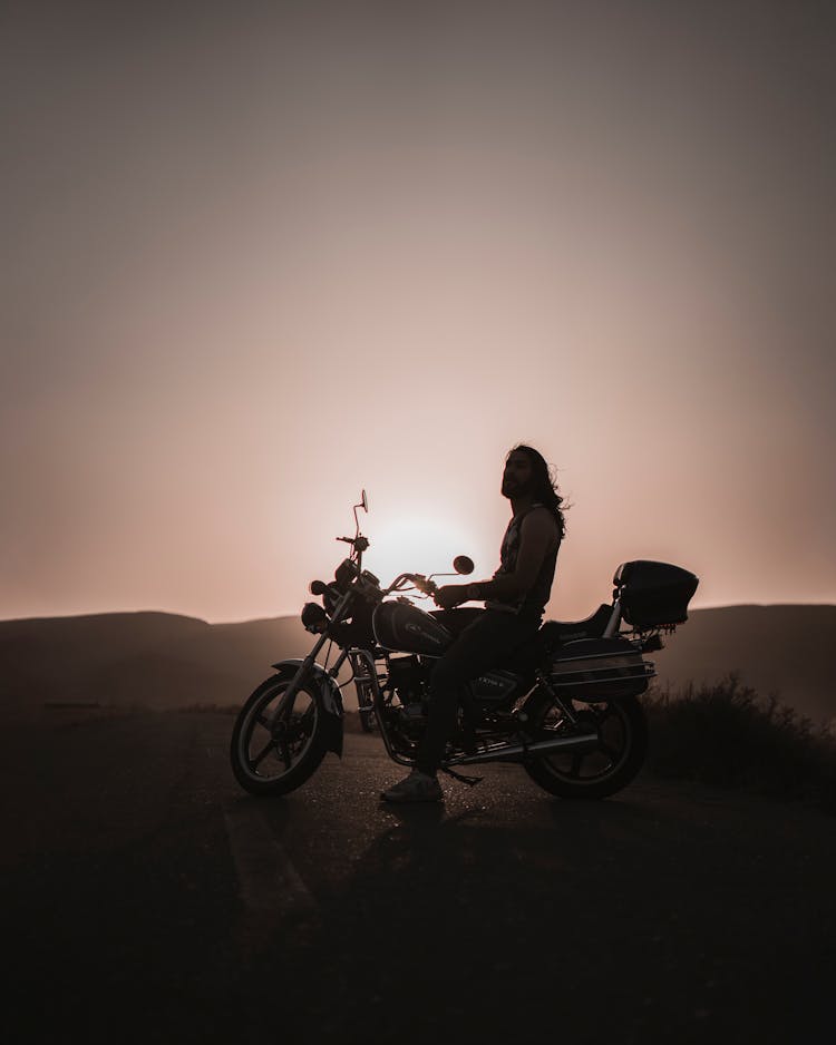 Silhouette Of Man On Motorbike On Sunset