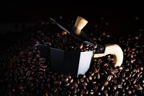 Close-Up Photograph of a Moka Pot with Coffee Beans