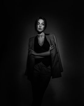 Chic black and white portrait of a stylish woman in a studio shoot, exuding elegance.