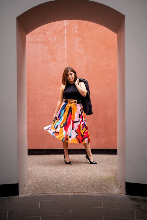 Free Female Fashion Model Posing in a Doorway With a Jacket Held Over the Shoulder Stock Photo