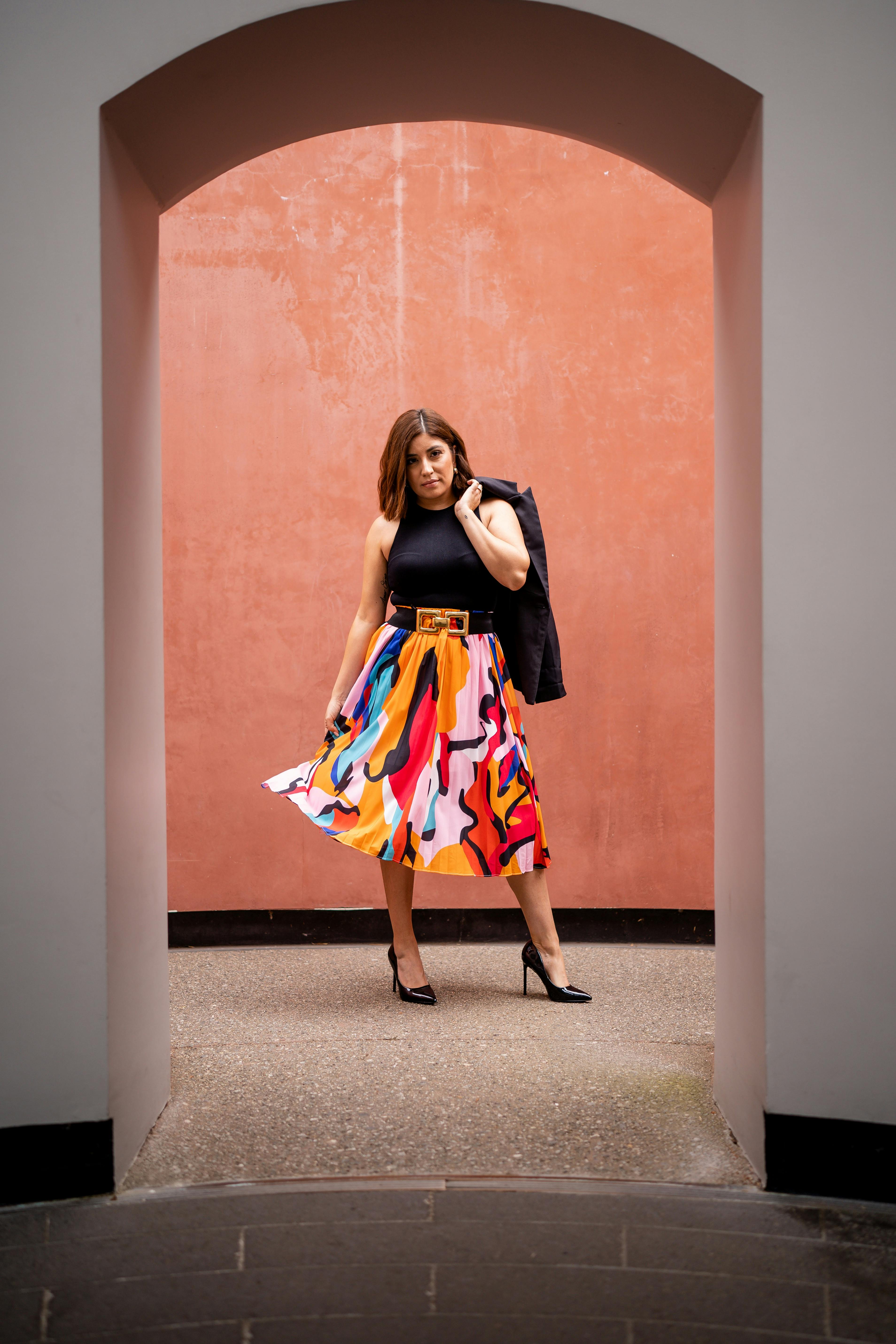 Female Fashion Model Posing in a Doorway With a Jacket Held Over the Shoulder · Free Stock Photo