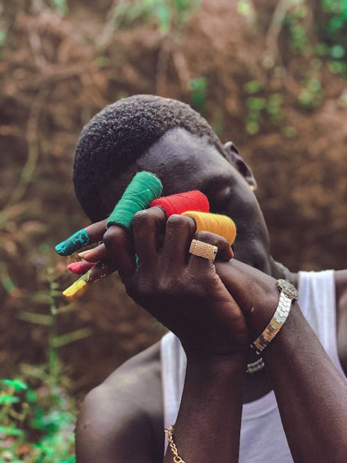 African Man Holding Colorful Sewing Threads 