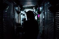 城市小巷中，一个背光的黑暗剪影营造出神秘的氛围