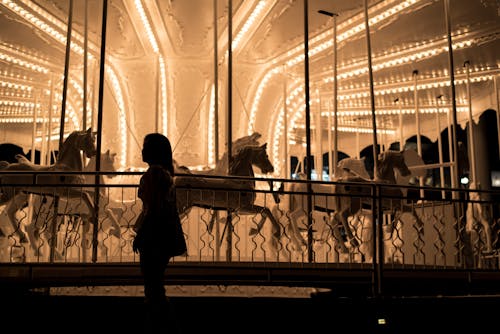 Girl Standing Near Carousel