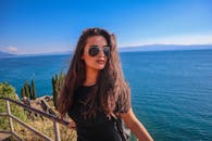 阳光明媚的日子里，一位戴着墨镜的女人在宁静的奥赫里德湖边放松