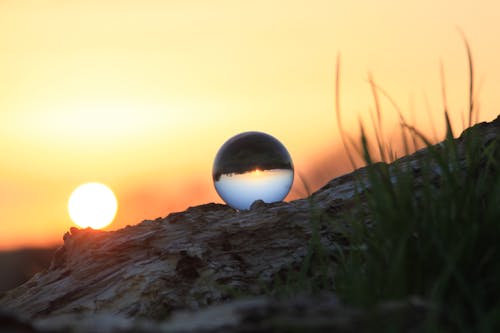 日没時の茶色の岩層のガラス玉の写真