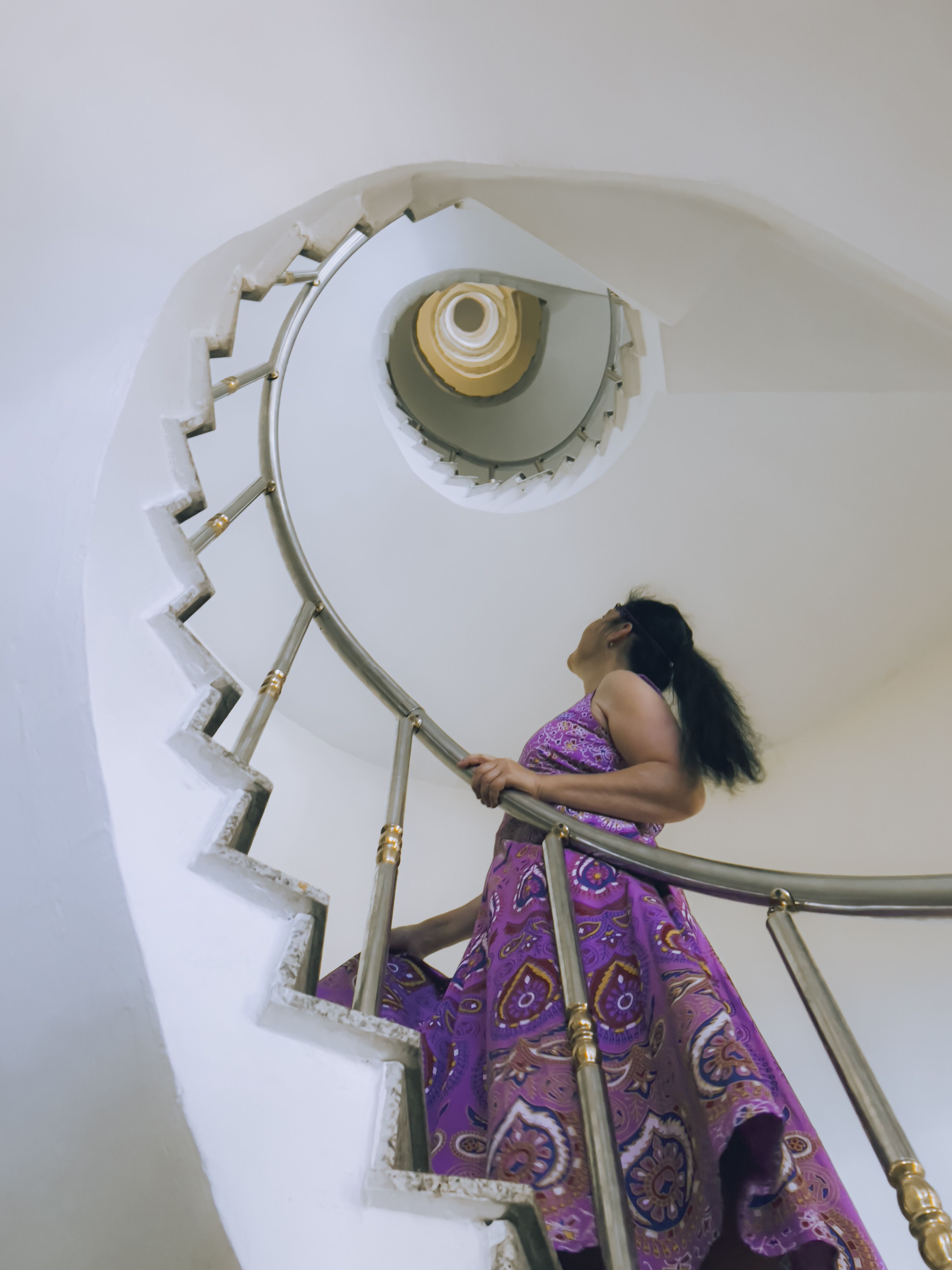 A Woman in Purple Dress Walking on a Spiral Staircase · Free Stock Photo