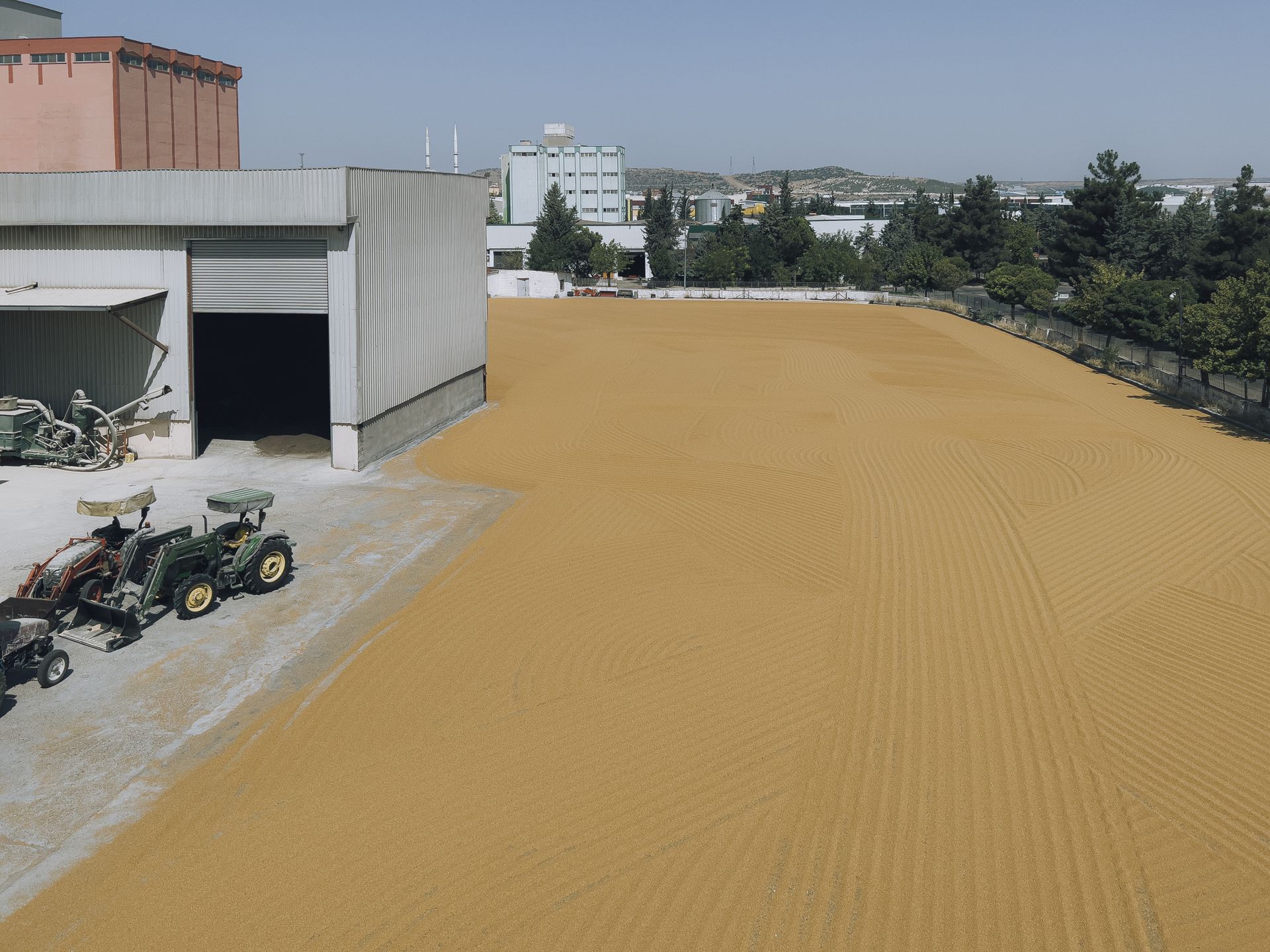 Smooth Sandy Yard next to a Building and Tractors