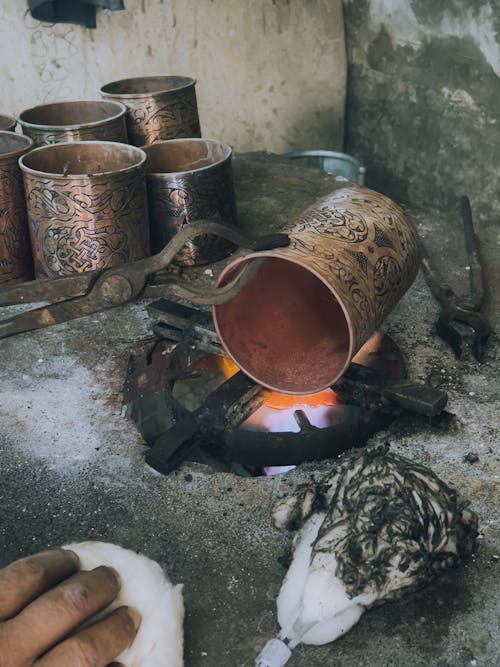 Blacksmith Heating Up Metal Pot over Fire