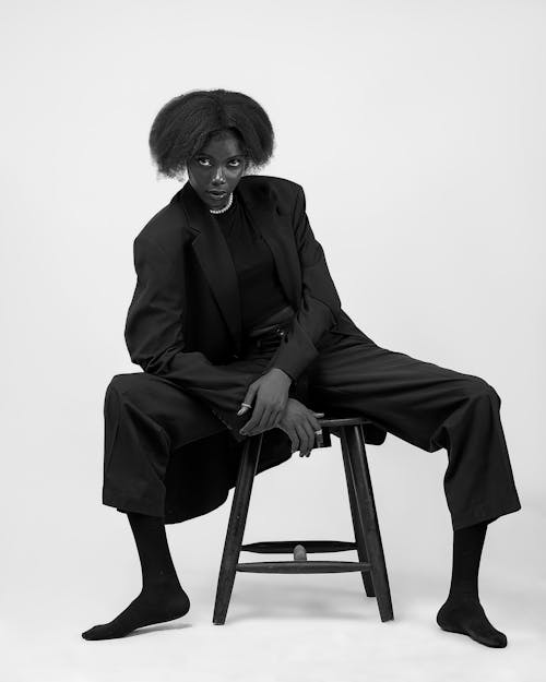 Elegant Woman Sitting on Stool in Studio