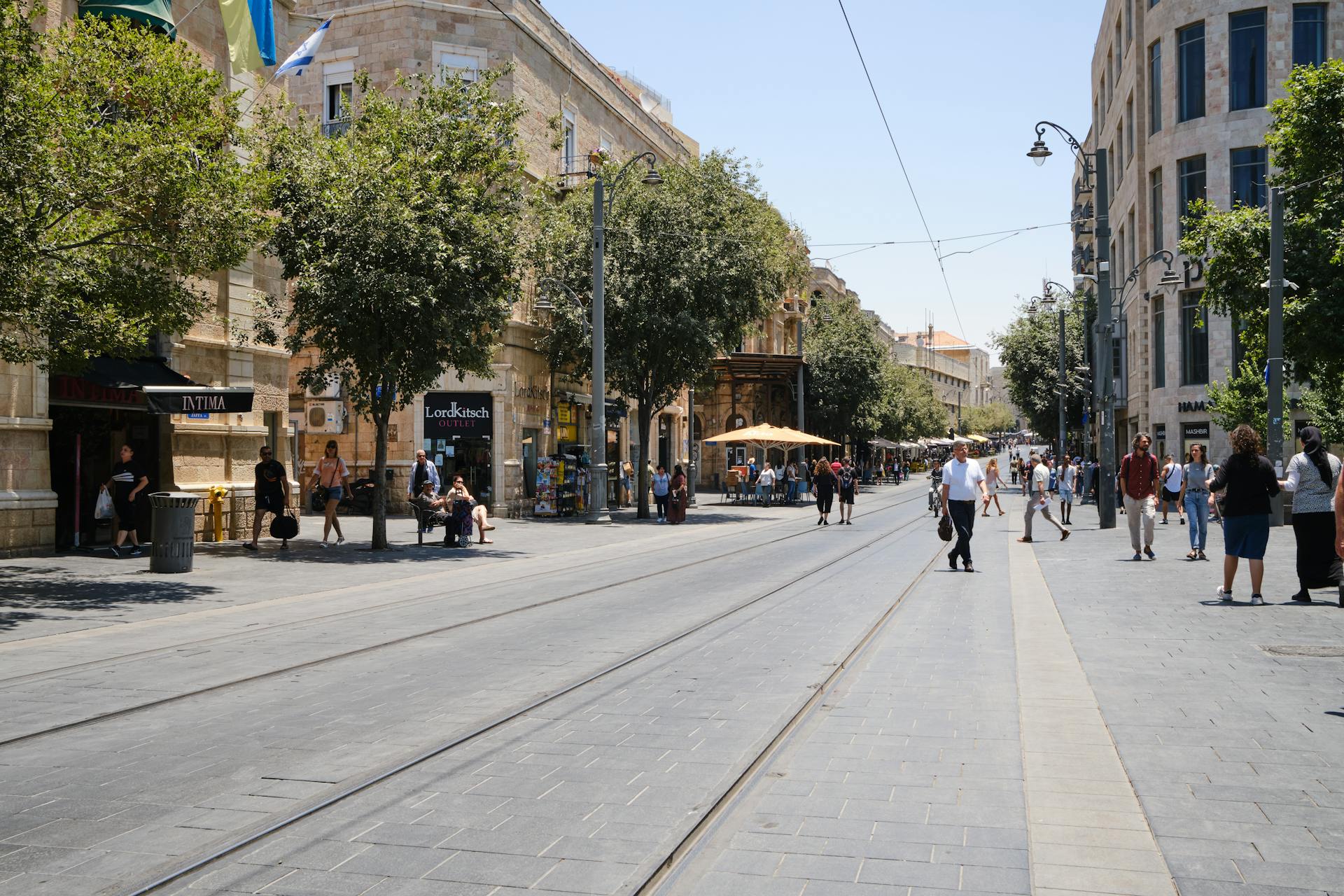 Lively day on Jaffa Street, Jerusalem with pedestrians and tram tracks.