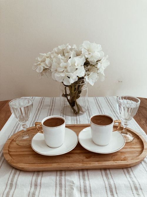 Free Two coffee cups on a wooden tray with white flowers, creating a serene atmosphere. Stock Photo