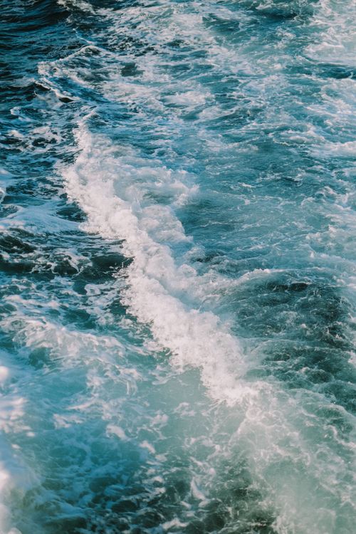 Free Dynamic ocean waves crashing with vibrant white foam under bright daylight, showcasing the sea's beauty. Stock Photo