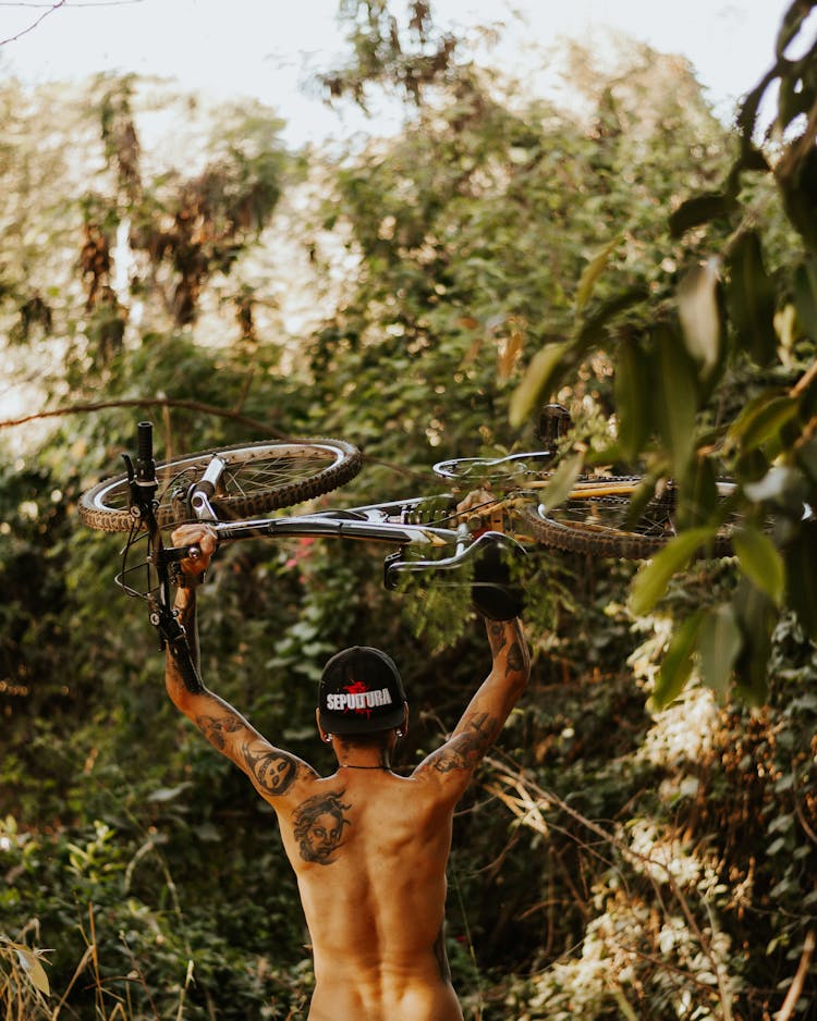 A Man Carrying A Bicycle 