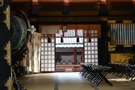 View of a serene interior of a traditional Japanese temple with tatami mats and decorative elements.