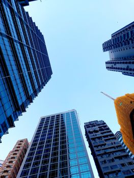 A low angle view of modern skyscrapers in Hong Kong, showcasing architectural symmetry and glass facades.