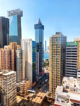 Stunning aerial view of Hong Kong's urban skyline with towering skyscrapers and a bustling city street below.