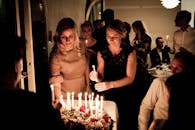 室内庆祝活动温暖舒适，蜡烛和客人围着桌子布置