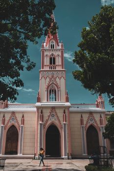 Vibrant Gothic-style church facade in Mérida, Venezuela, framed by lush trees.