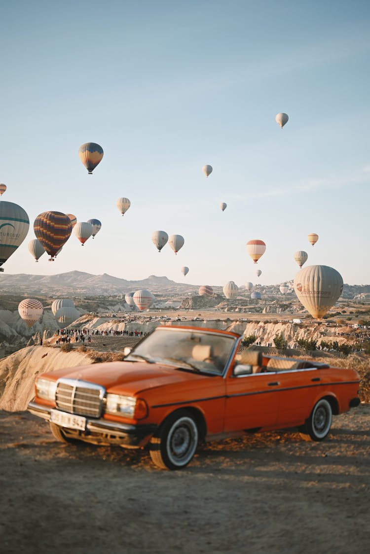 Retro Car With Hot Air Balloons In Landscape